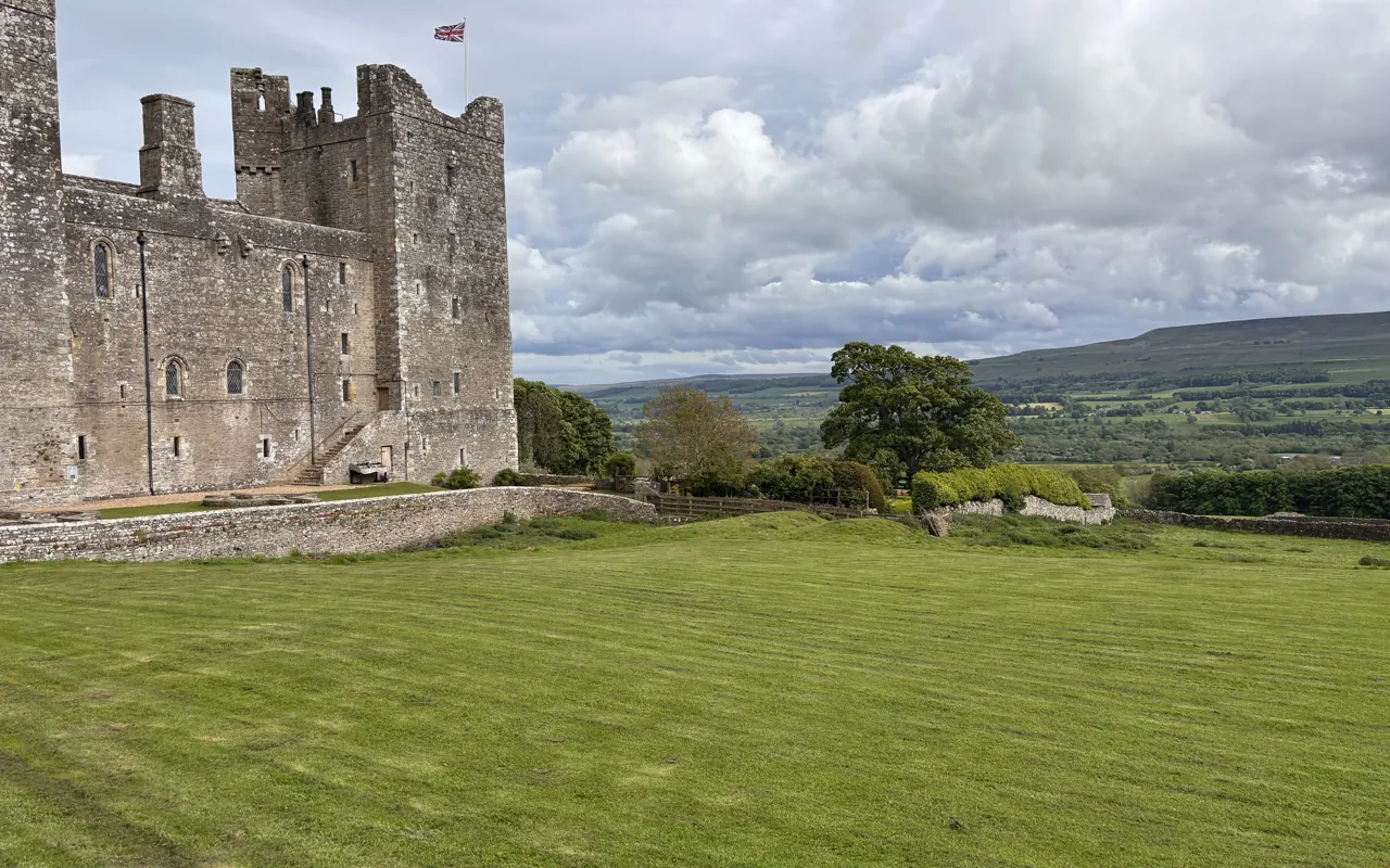 Ruined medieval castle set in green Yorkshire Dales fields on the Dales and Castles tour