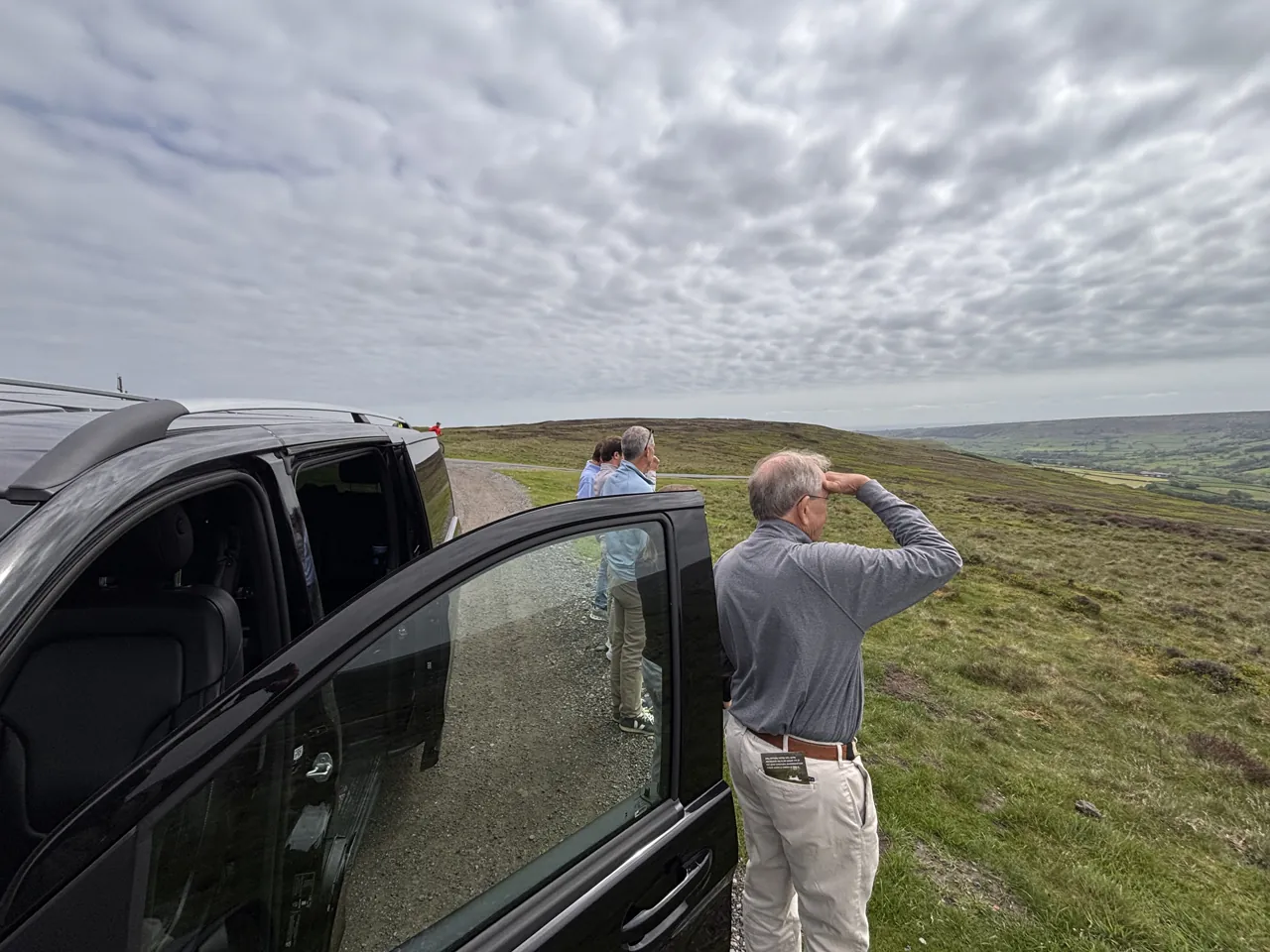 Expedition Yorkshire driver-guide and guest beside the Mercedes V-Class at a moor-top viewpoint in Yorkshire